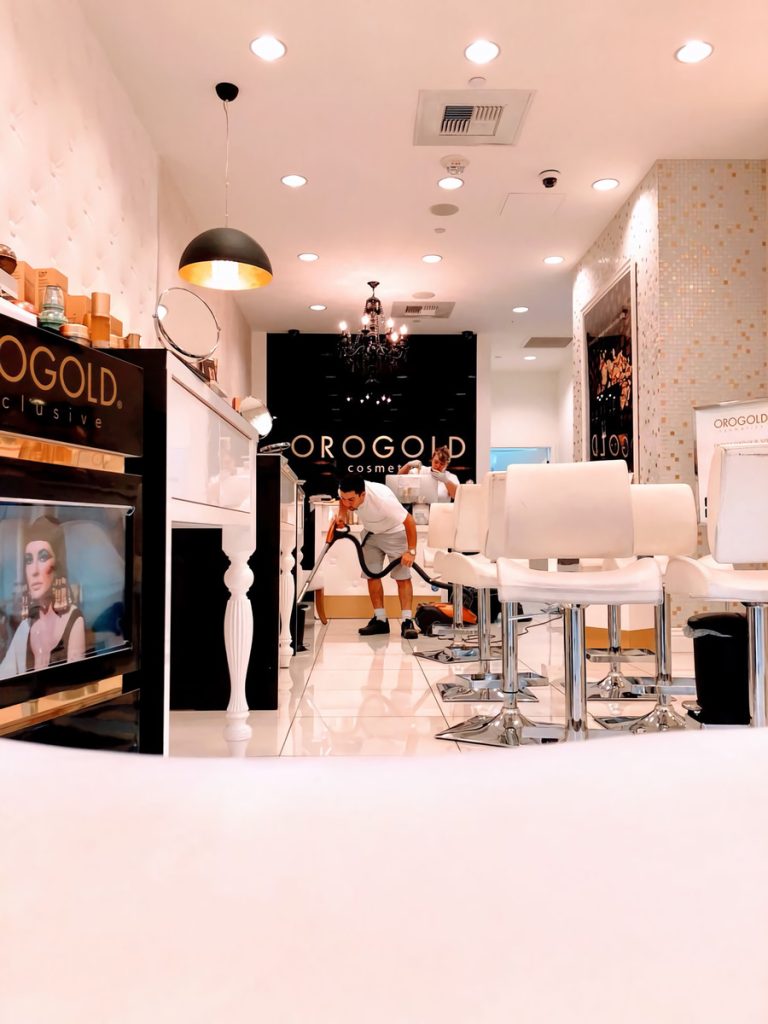 A modern salon featuring white chairs and a large mirror, creating a bright and inviting atmosphere for clients.
